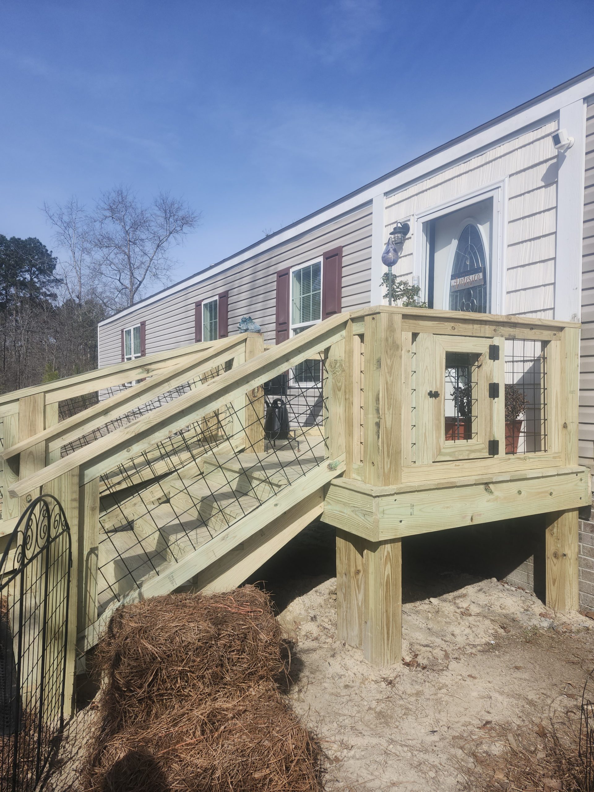 Custom pressure-treated deck with metal cable railings and enclosed addition built by professional contractors in South Carolina.